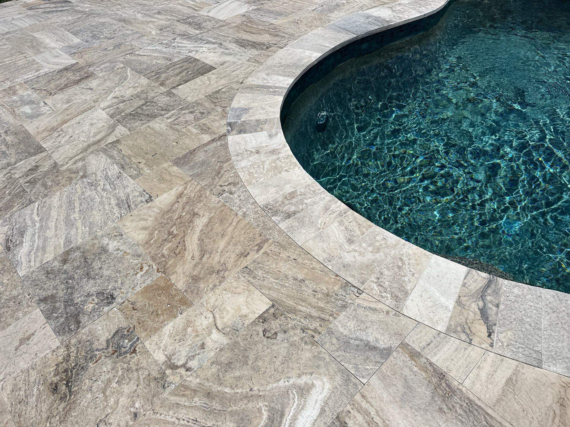 Before and after pool resurfacing in Anna Maria FL with Alaskan Silver Travertine and Luv Tile by Nelson Pool Company — after