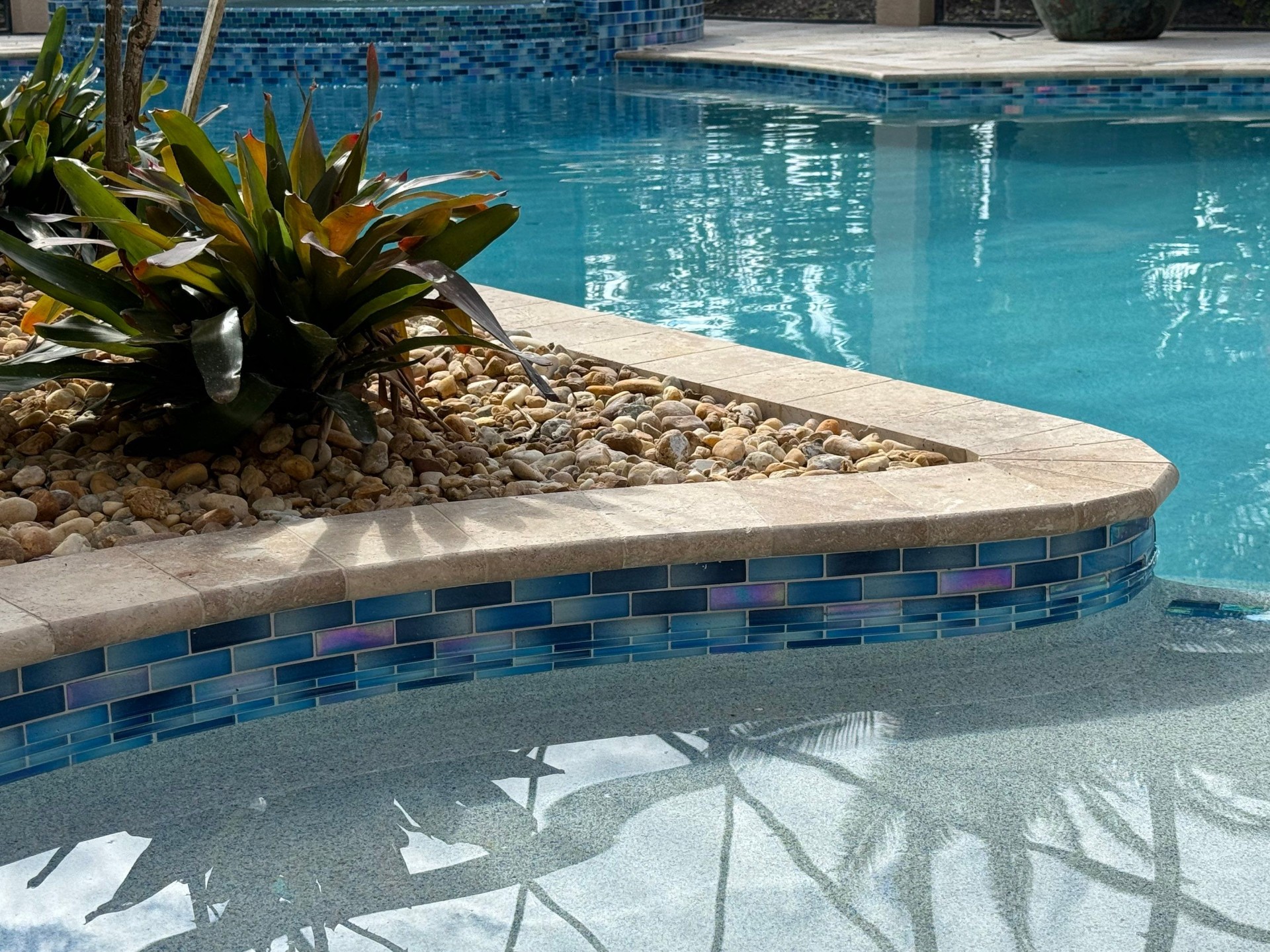 Travertine paver deck and coping around a renovated pool by Nelson Pool Company