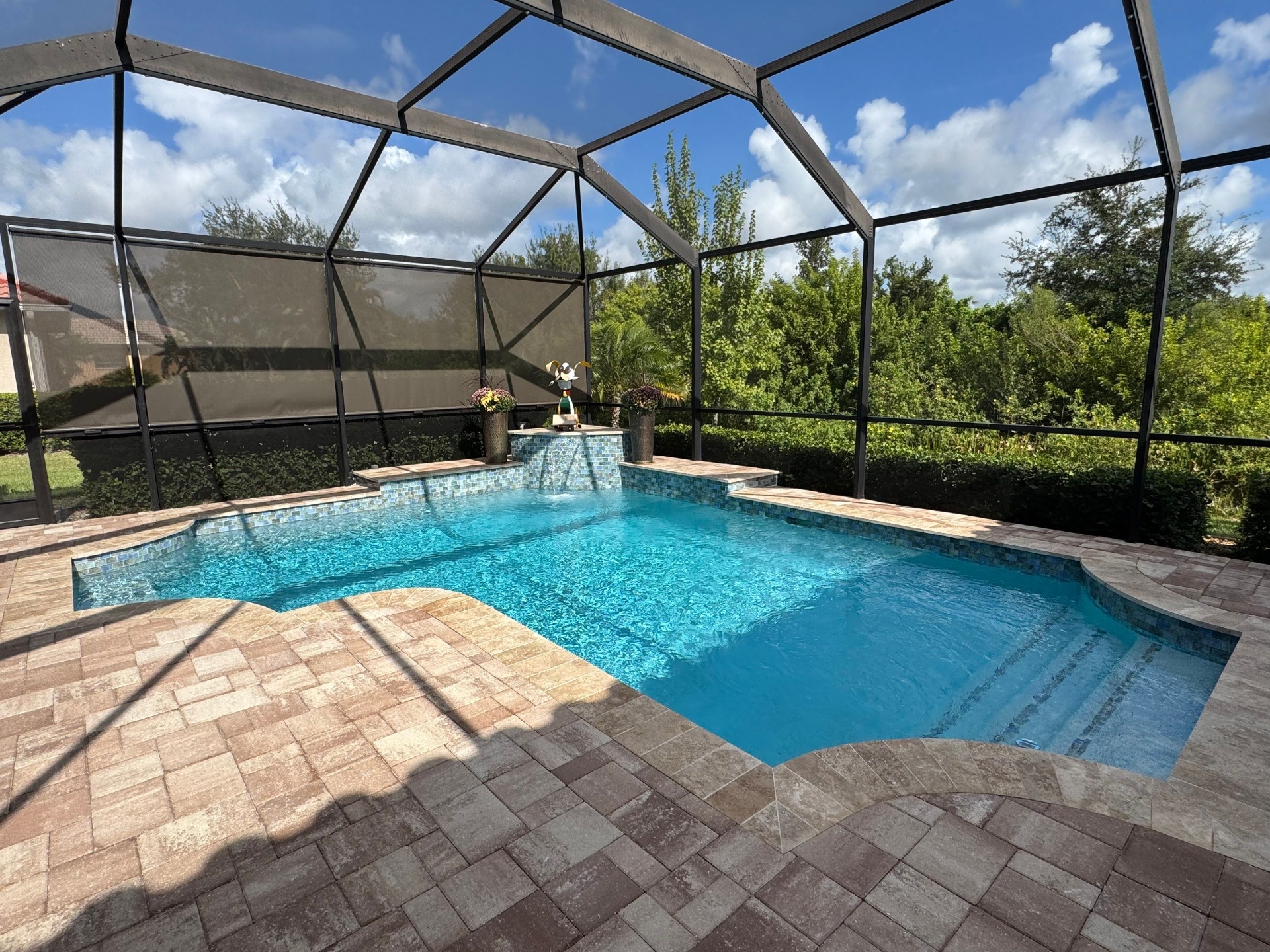 Before and after pool renovation in Parrish FL with Luv Tile, Pebble Crystal Buff Blue, and Mocha Plus Travertine by Nelson Pool Company — after