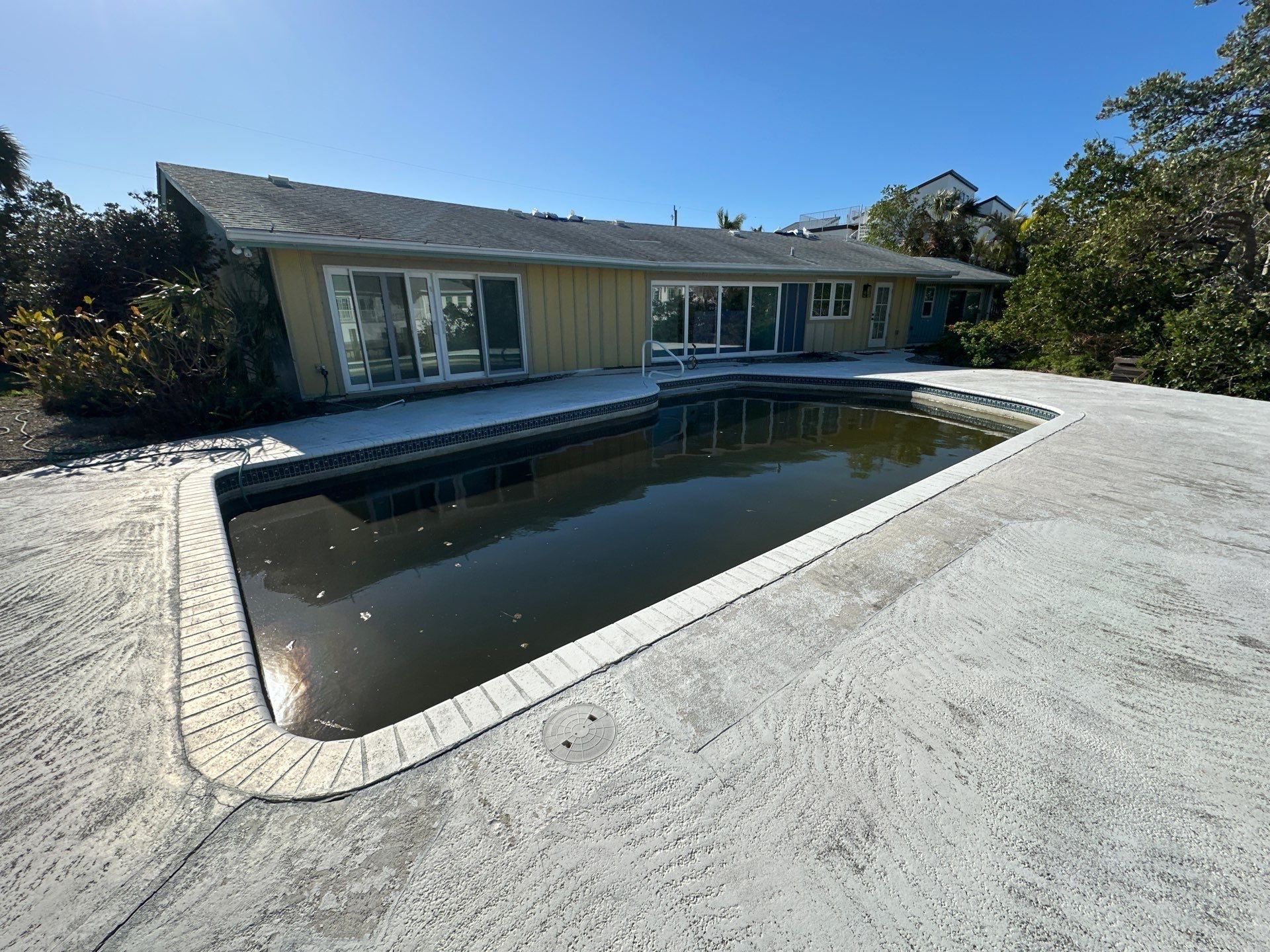 Before and after pool renovation in Holmes Beach FL with Royal Beige Marble, Luv Tile, and StoneScapes Aqua Blue by Nelson Pool Company — before