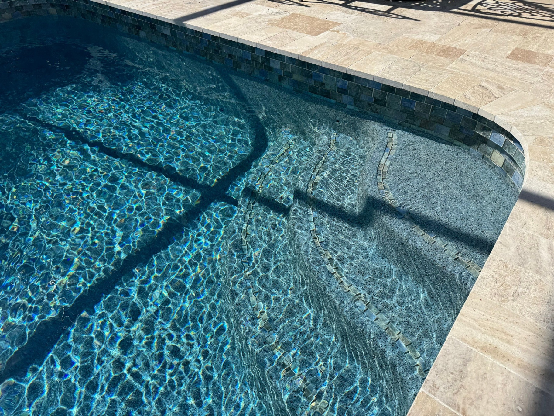 Before and after pool remodel in Venice FL with Norwegian River Travertine, Luv Tile, and Pebble Sheen Blue Surf by Nelson Pool Company — after