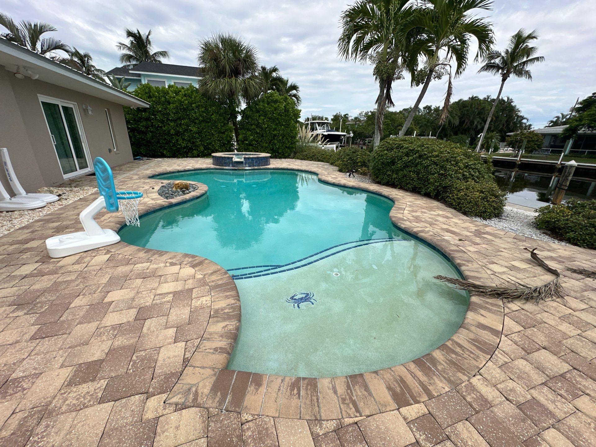 Before and after pool renovation in Longboat Key FL with Crema Bella Marble, Luv Tile, and StoneScapes Aqua White by Nelson Pool Company — before