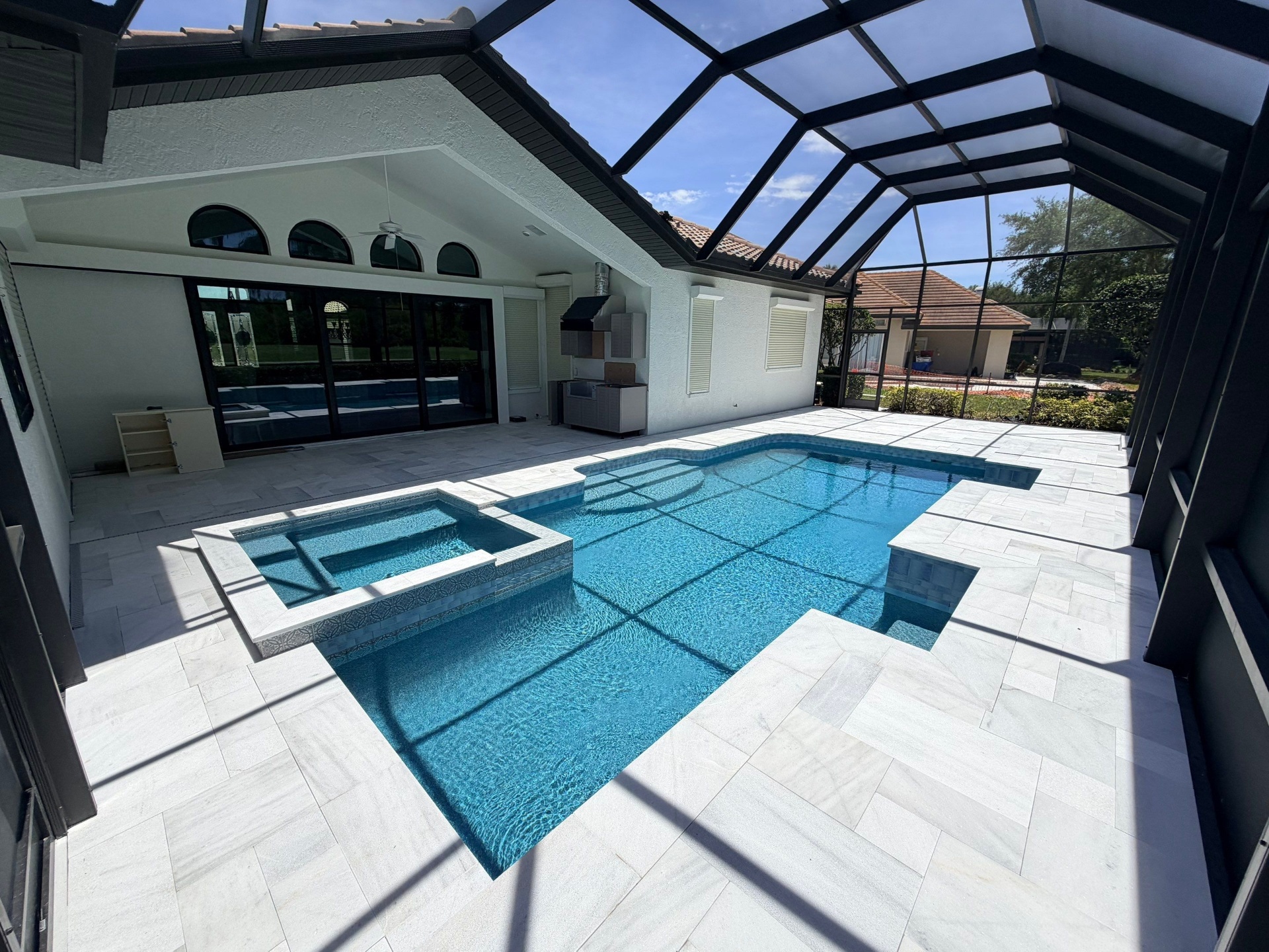 Before and after pool renovation in Lakewood Ranch FL with Wet Edge Brilliant Blue, Abalone Shell, and Mykonos Marble pavers by Nelson Pool Company — after